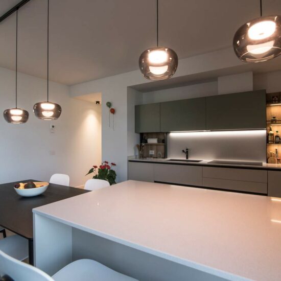 realizzazione cucina con penisola, tavolo e illuminazione Bergamo